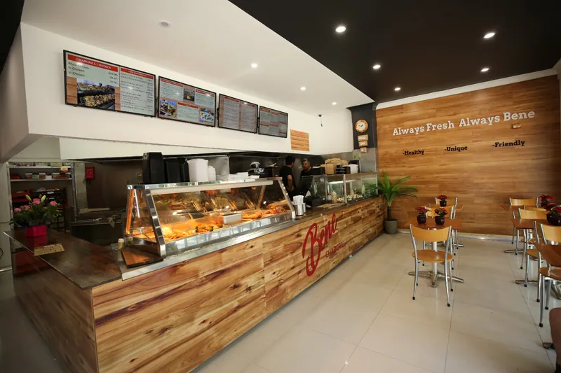 Completed café fit-out with timber-clad counter, display cabinet and pendant lights