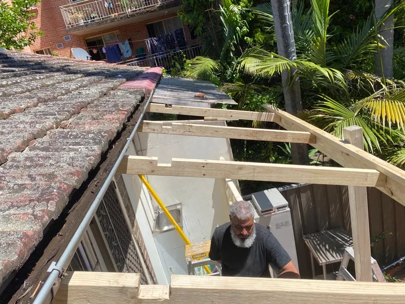 Carpenter fixing framing at the roof edge